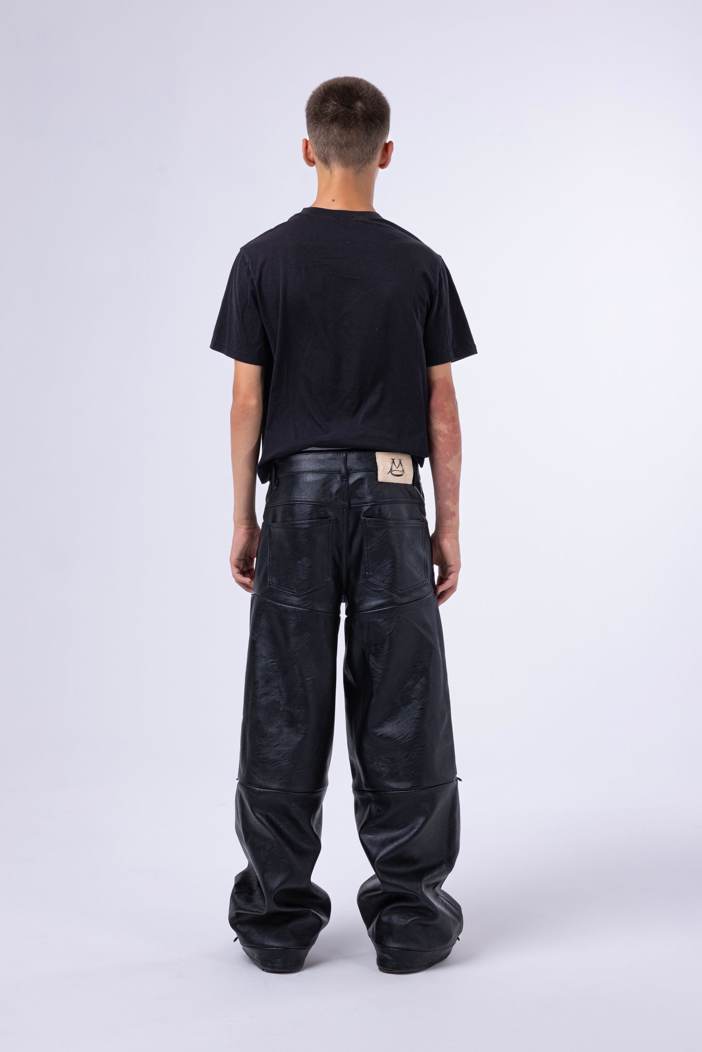 Jeans modulari MO Interchangeable indossati da uomo, vista posteriore, su sfondo neutro